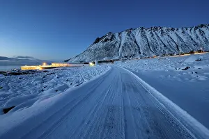 Framed Print : Iced snow road, illuminated village in twilight