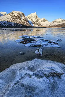 Icy fjord in front of steep mountains