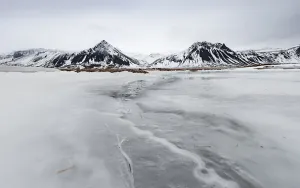 Icy landscape, volcanic black mountains with snow
