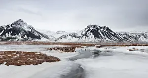 Icy landscape, volcanic black mountains with snow