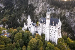 An imposing castle surrounded by dense forests in the mountains