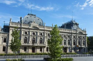 An imposing historic building with an ornate facade and baroque elements under a clear blue sky
