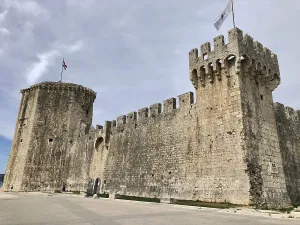 Imposing medieval stone castle with fortified walls and flags