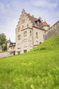 Impressive historic building with gabled roof and green meadow