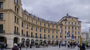 Impressive historic building in an urban environment with people and flags