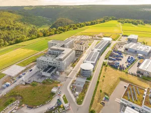 Industrial building under construction with solar panels and surrounding landscape