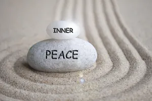 Inner peace text engraved on Zen stone on sand with shining