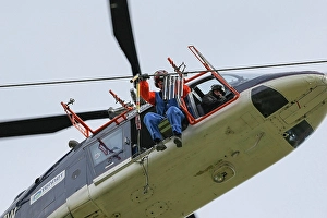 Installation of bird protection markings on overhead power lines by helicopter, worker installing bird deflectors on high-voltage power lines, close-up, 10 April 2017, Affoldern, Hesse, Germany, Europe