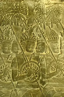 Intricate stone relief, warriors with spears and shields in front of trees