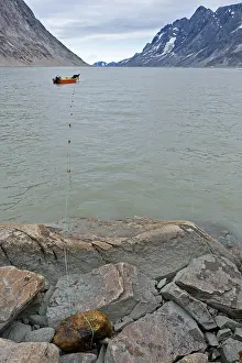 Inuit hunter sets net in fjord