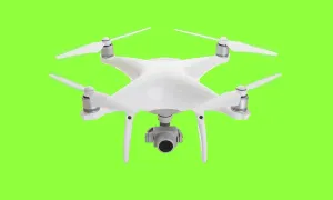 Isolated unmanned aircraft system (UAV) quadcopter drone in the air over A green screen