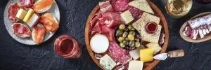 Italian antipasti or Spanish tapas panorama on a black background