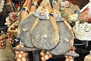 Italian hams and sausages presented in baskets at a market
