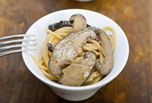 Italian spaghetti pasta and fresh wild mushrooms on rustic wood table