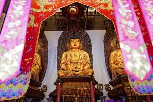 Jade Buddha Temple, Shanghai, Buddha in meditation posture behind colourful curtains on a richly decorated altar