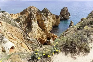 Jagged rocks on the coast of the Algarve with a path along the cliffs
