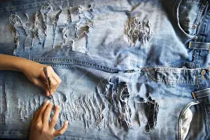 Framed Print : Jeans being torn, holes in the trousers