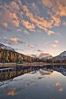 Jetty and lake in front of mountains and trees in autumn colors
