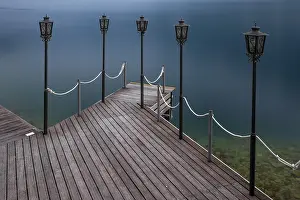 Jetty with lamps jutting out into calm blue water