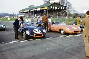 John Coundley (32), brown Jaguar E Type, and Bill de Selincourt (33), Jaguar Lister Knobbly, sports car race at Goodwood, March 1961, on the starting line