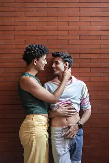 A joyful gay couple embracing and smiling at each other