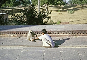 Junge hockt bei einem Affen, Uttar Pradesh, Indien, 1964