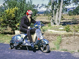 Junger Mann ruehrend auf Vespa GS Motorroller mit Helm, Culver Parade, Sandown, Isle of Whight, England, UK 1962