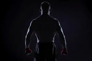 Kickboxer in red bandages posing on a blue background