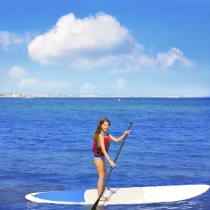 Kid paddle surf surfer girl with row in mediterranean beach