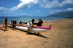 Kihei beach, an outrigger boat is pushed ashore by schoolgirls after physical education class, Maui Island, Hawaii, USA, North America