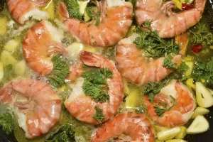 King prawns, tiger shrimps, with garlic and parsley in a pan