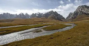 Kol Suu River between autumnal yellow meadows with mountain panorama of the Keltan Mountains