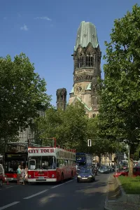 Kurfuerstendamm boulevard, with sightseeing buses and Kaiser Wilhelm Memorial Church on Breitscheidplatz square