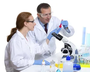 Laboratory with two scientist working with test tubes flask and microscope