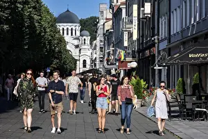 Laisves aleja in Kaunas with passers-by and the Church of Archangel Michael in the background