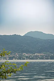 Lake Como with a small village on the shore and wooded mountains in the background