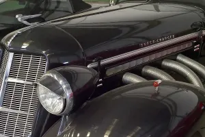 Lamp and radiator grille of a black Auburn Speedster from the side
