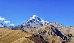 Landscape high rocky mountains of the Caucasus in Georgia on a background of blue sky and clouds