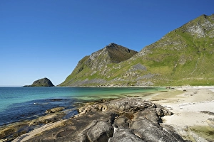 Landscape with sea at the sandy beach of Haukland with the mountain Veggen