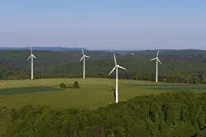 Landscape with wind turbines and green fields under a blue sky