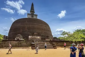 Large ancient stupa with people in the foreground on a sunny day