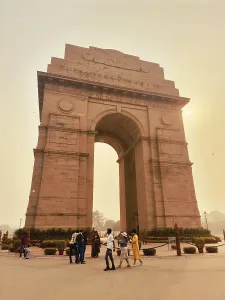 Large archway at dusk with people in the foreground and a sky slightly illuminated by the sun
