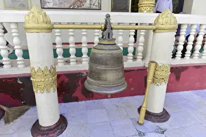 Large bell between decorated pillars in a temple area