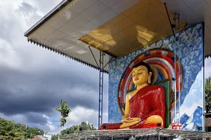 Framed Print : Large Buddha statue under a roof surrounded by rainbow and cloudy sky