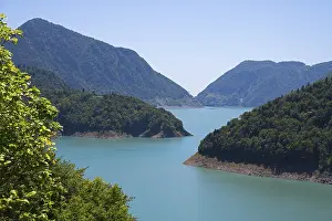 Large, calm lake surrounded by forested mountains