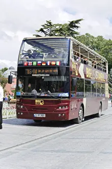 Large double-decker bus drives tourists through the streets