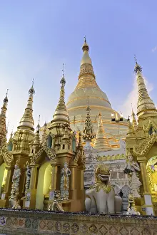 Large golden stupas under a blue sky in an evening mood