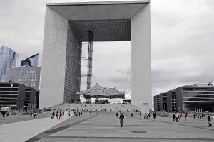 Large modern monument with people on the forecourt under a cloudy atmosphere