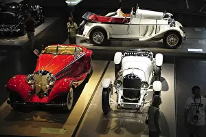 Large number of restored classic cars on display in a museum