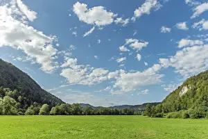 A large, open field with a clear blue sky and a few clouds